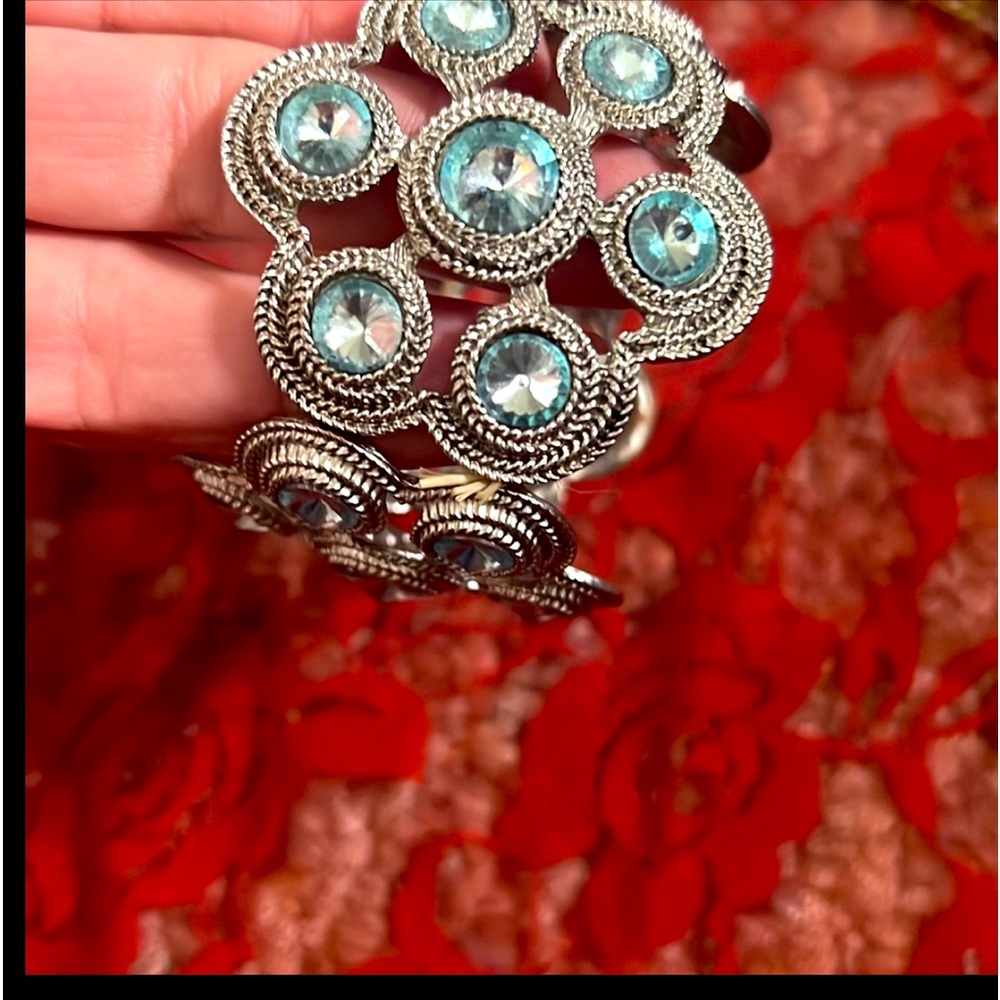 Two bracelets. One is stretch, Blue and silver and one has a clasp, tan and gold